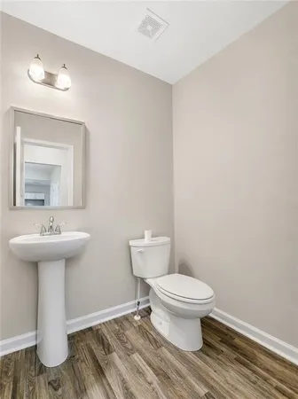 a bathroom with a granite countertop sink a toilet and a mirror