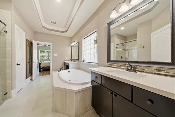 a spacious bathroom with a double vanity sink mirror and bathtub
