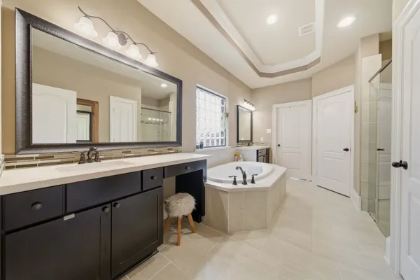 a bathroom with a tub sink shower and mirror