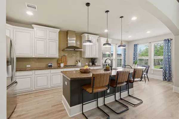 a large kitchen with a table and chairs