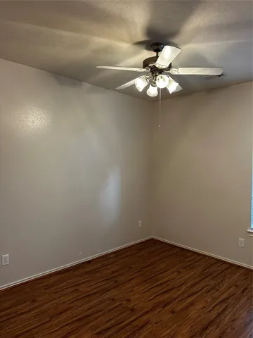 a view of a room with wooden floor closet and a chandelier fan