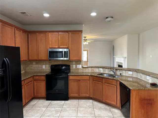 a kitchen with a sink a stove top oven and refrigerator