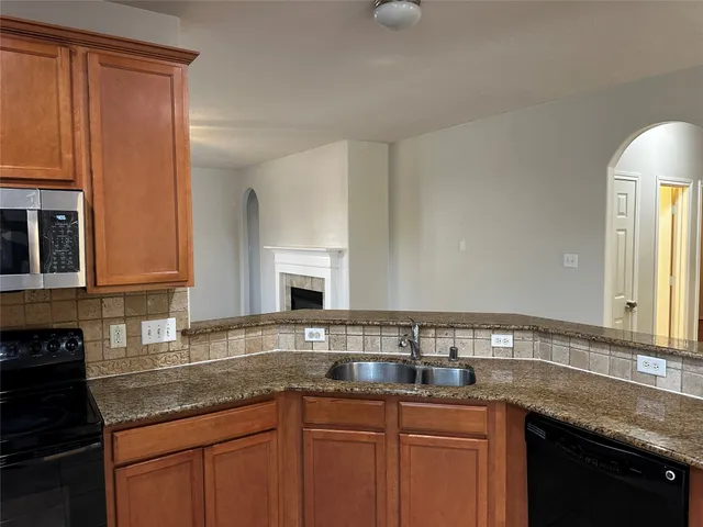 a kitchen with granite countertop a sink and cabinets