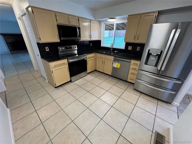 a kitchen with stainless steel appliances a refrigerator and a microwave