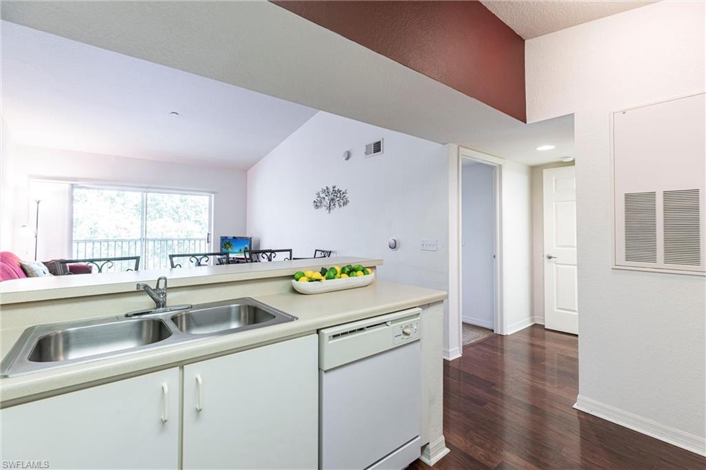 8274 Key Royal Circle, Unit 1036 Naples, FL 34119 - Photo 11 of 45 Kitchen with white dishwasher, light countertops, dark wood finished floors, and white cabinets