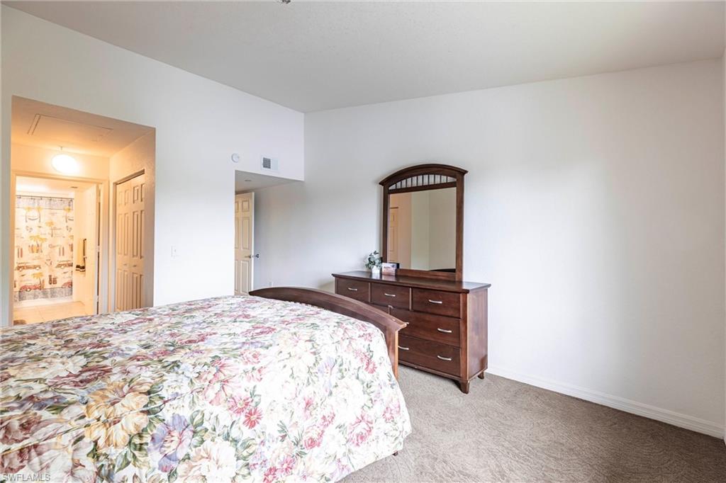8274 Key Royal Circle, Unit 1036 Naples, FL 34119 - Photo 13 of 45 Bedroom featuring light carpet, attic access, and ensuite bath