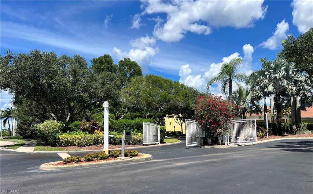 8274 Key Royal Circle, Unit 1036 Naples, FL 34119 - Photo 45 of 45 View of asphalt road with a gate, curbs, and a gated entry