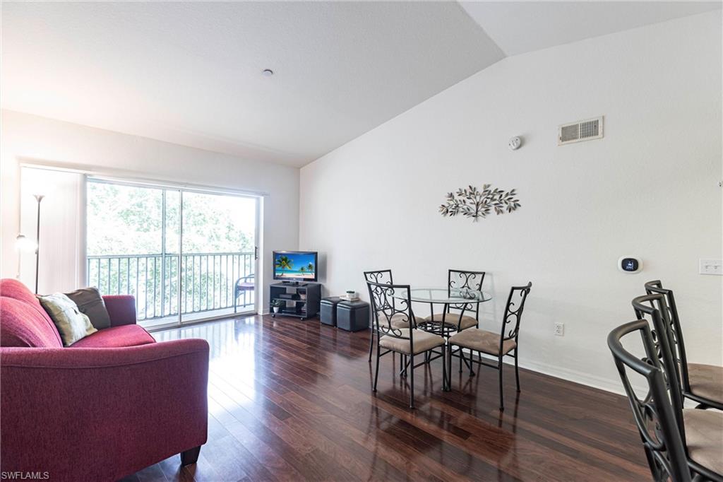 8274 Key Royal Circle, Unit 1036 Naples, FL 34119 - Photo 5 of 45 Dining room with vaulted ceiling and wood finished floors