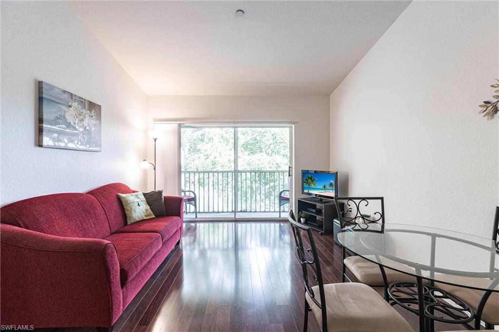 8274 Key Royal Circle, Unit 1036 Naples, FL 34119 - Photo 6 of 45 Living room with a textured wall and hardwood / wood-style flooring