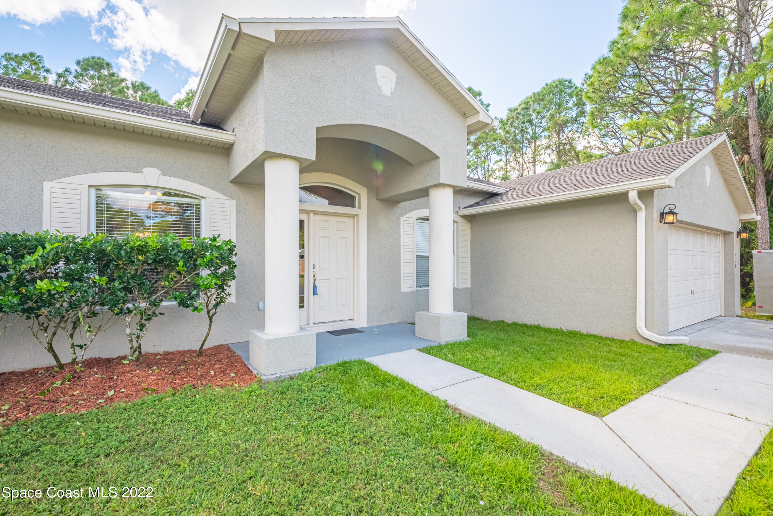 1744 Hydrangea Road Palm Bay, FL 32907 - Photo 3 of 34 a front view of a house with a yard and garage