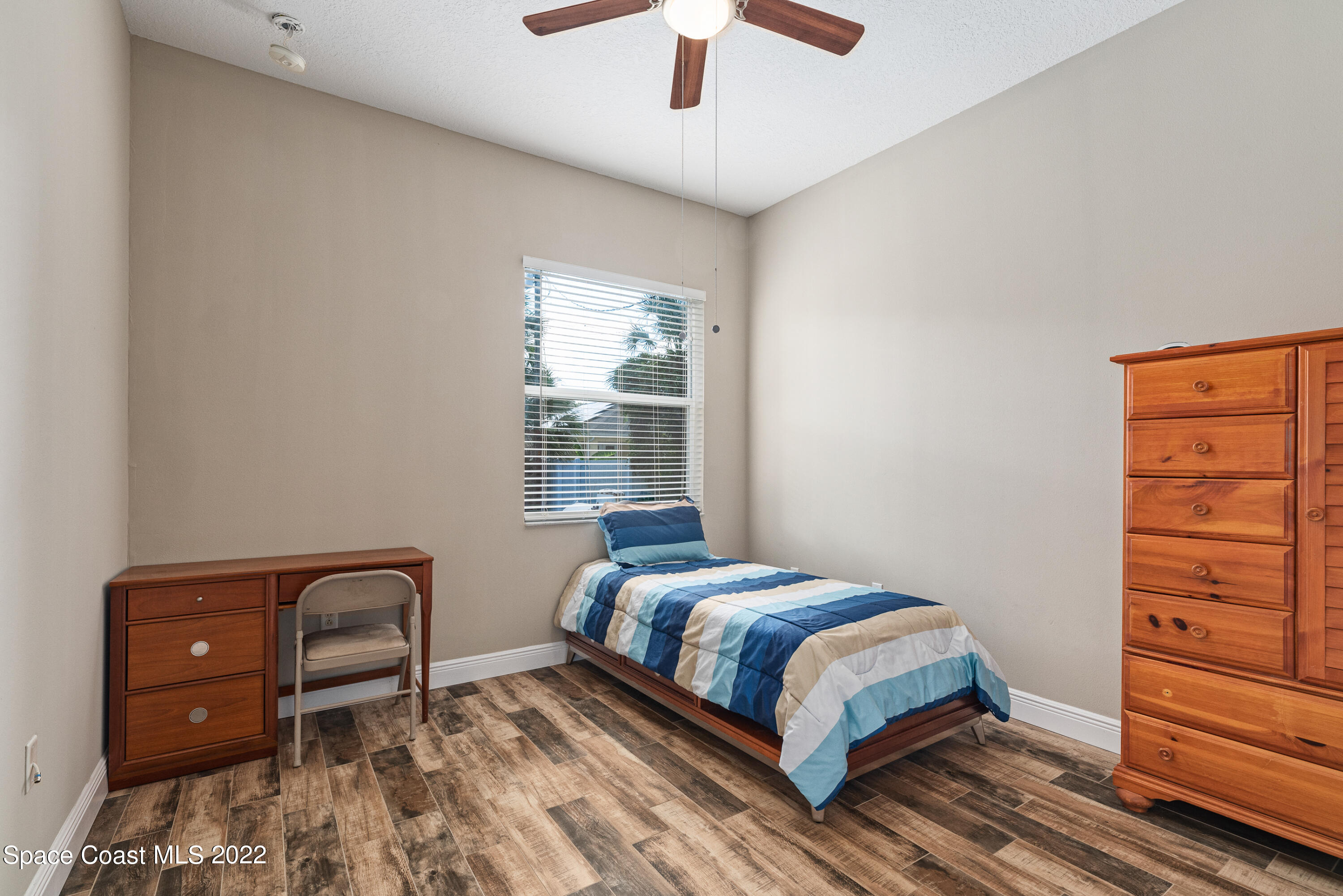 1744 Hydrangea Road Palm Bay, FL 32907 - Photo 32 of 34 a bedroom with a bed and a dresser