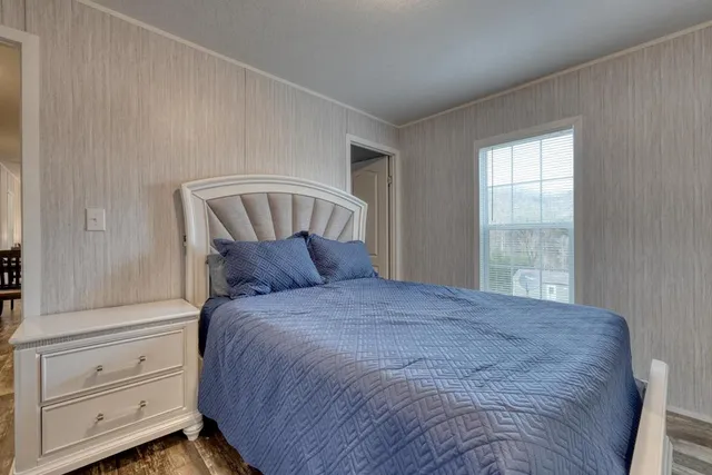 a large bed sitting in a bedroom next to a window