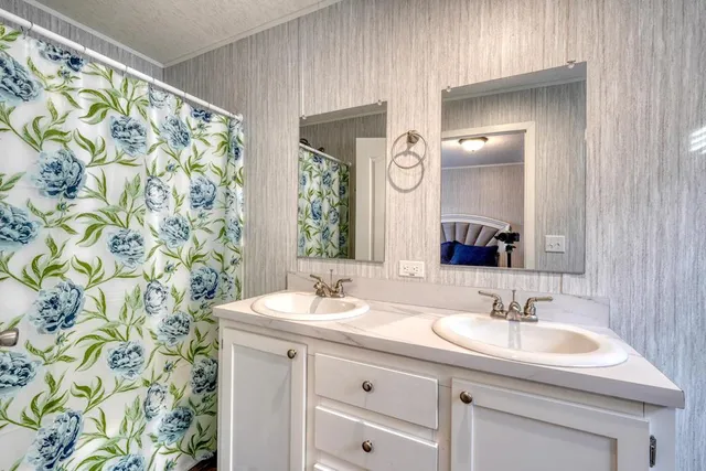 a bathroom with a granite countertop sink a mirror a vanity and a shower