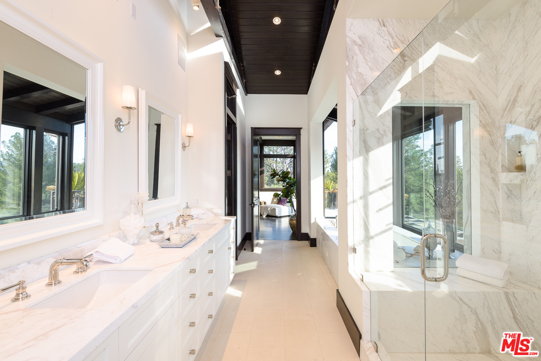 2175 Summitridge Drive Beverly Hills, CA 90210 - Photo 27 of 51 a spacious en suite bathroom with a double vanity sink and a large mirror