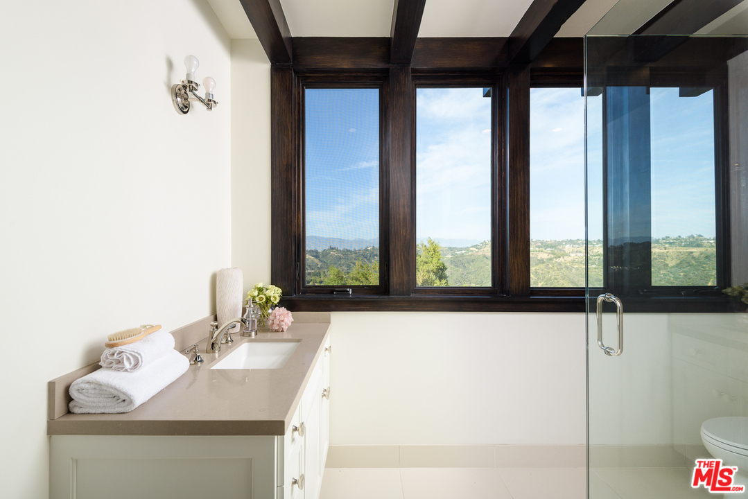 2175 Summitridge Drive Beverly Hills, CA 90210 - Photo 33 of 51 a dining table sitting next to a window