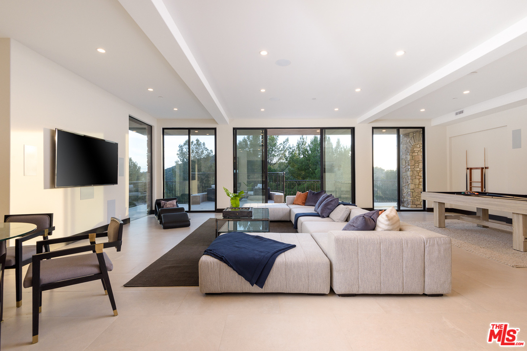 2175 Summitridge Drive Beverly Hills, CA 90210 - Photo 38 of 51 a living room with furniture and a flat screen tv