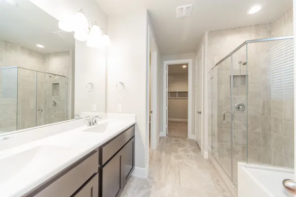 a spacious bathroom with a shower sink vanity and mirror