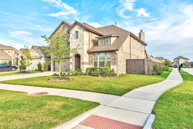 a view of a big house with a big yard and potted plants