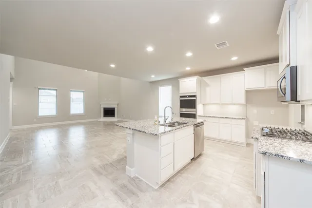 a kitchen with stainless steel appliances granite countertop a stove a sink and a refrigerator