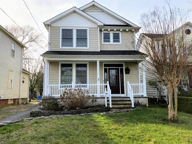 a view of a house with a yard and large tree