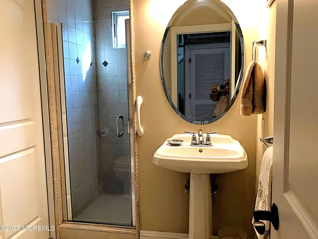 a bathroom with a sink a mirror and shower