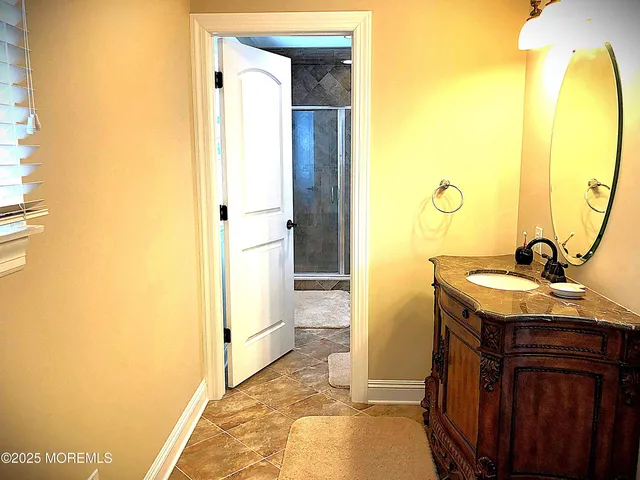 a bathroom with a granite countertop sink and a mirror
