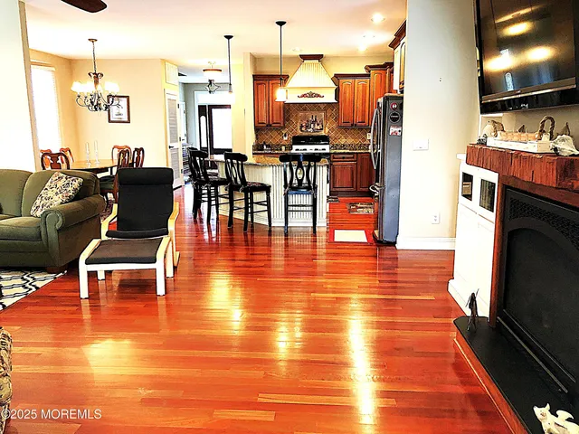 a living room with stainless steel appliances furniture stove and kitchen view