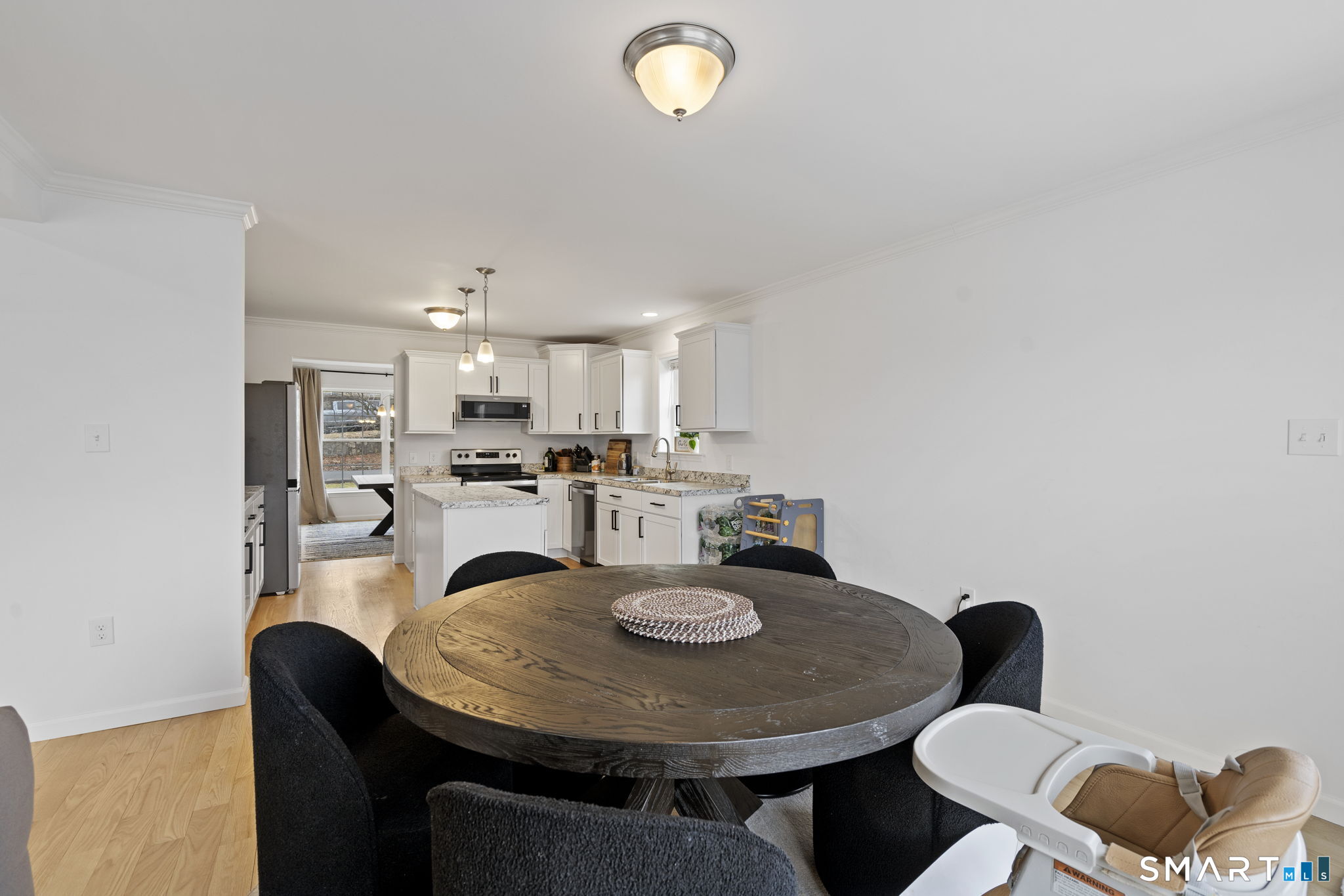 156 Dayton Road Bridgeport, CT 06606 - Photo 8 of 28 a kitchen with a dining table chairs and a refrigerator