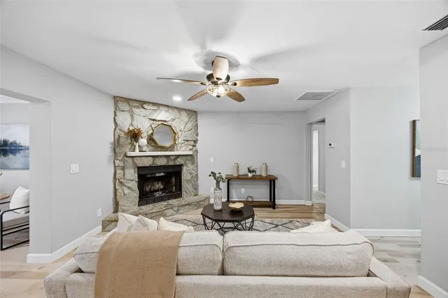 a living room with furniture a fireplace and a chandelier