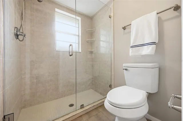 a white toilet next to a bathroom