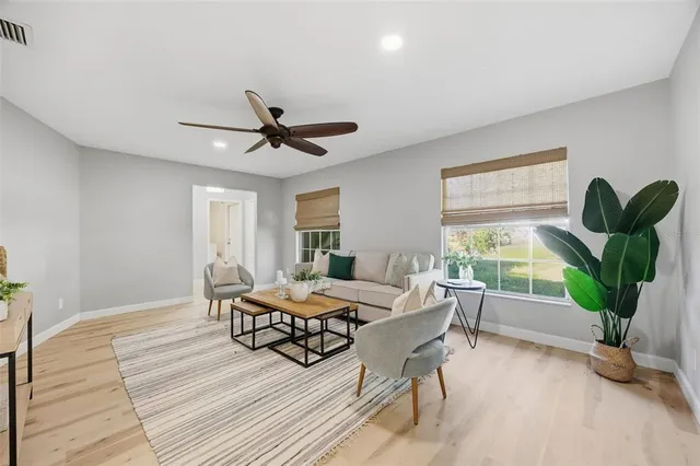 a living room with furniture a window and a potted plant