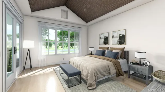a bedroom with a bed wooden floor and a large window