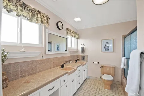a bathroom with a granite countertop toilet sink and mirror