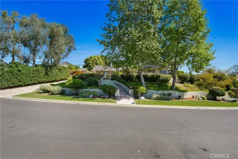 front view of a house with a yard and potted plants