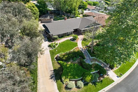an aerial view of a house with a yard and green space