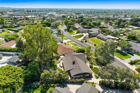 an aerial view of residential houses with outdoor space and trees