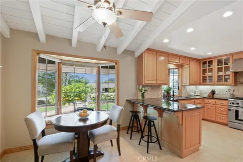 a room with stainless steel appliances kitchen island granite countertop furniture and a large window