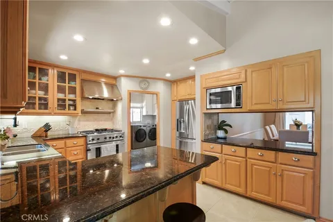 a kitchen with stainless steel appliances granite countertop a stove top oven a sink dishwasher and cabinets with wooden floor