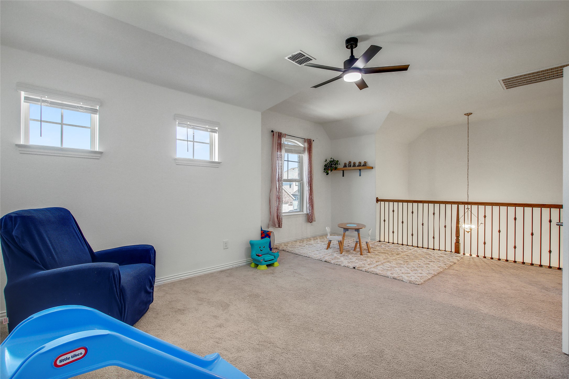 104 Millbend Road Georgetown, TX 78633 - Photo 33 of 40 A versatile open loft space featuring vaulted ceilings, plush carpeting, and a stylish ceiling fan.