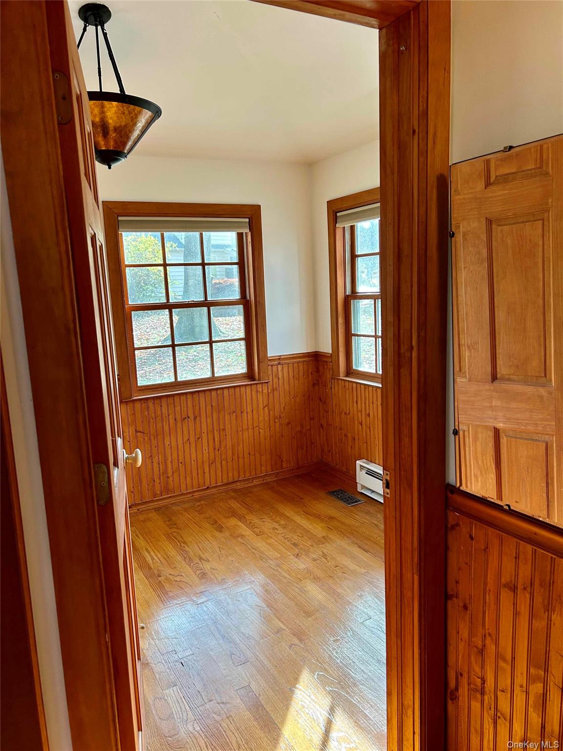 186 Taylor Road Cornwall, NY 10953 - Photo 14 of 26 Bedroom with a baseboard radiator, wood walls, and light hardwood / wood-style flooring