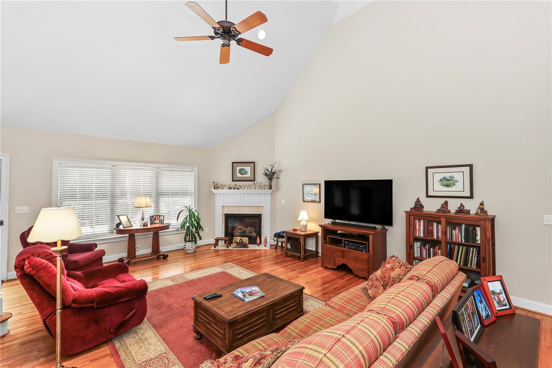 103 C-10-147D Anderson, SC 29621 - Photo 12 of 49 A comforting living area with a vaulted ceiling offers a inviting fireplace and hardwood flooring.