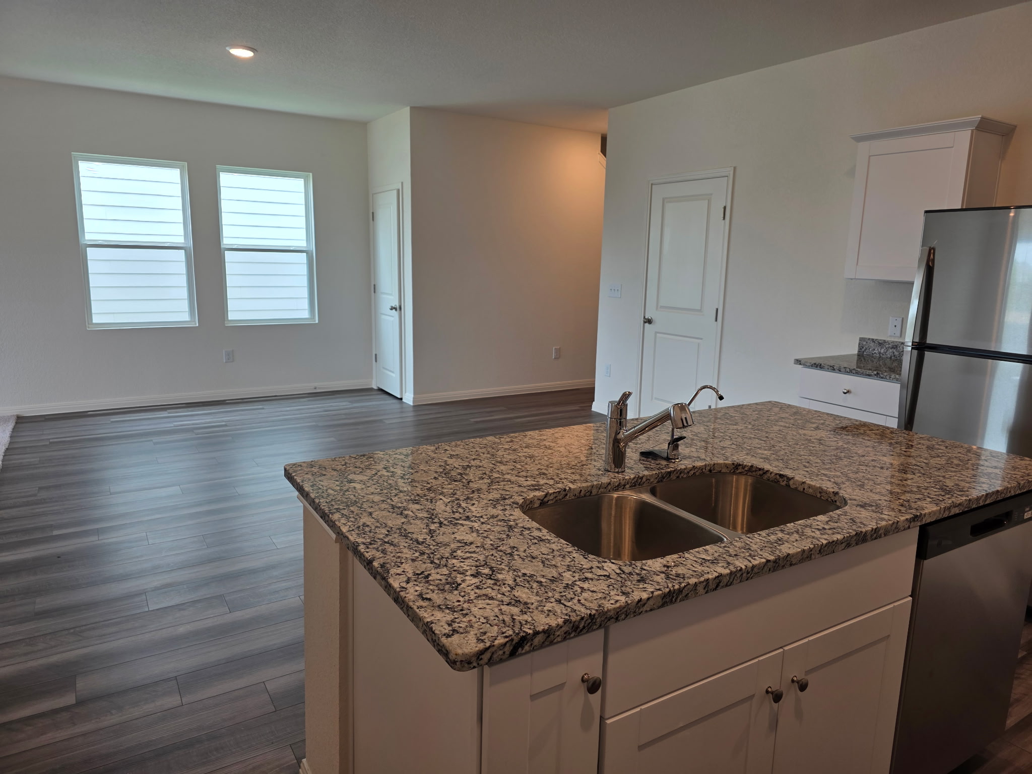 353 Enforcer Loop Jarrell, TX 76537 - Photo 5 of 21 Kitchen with stainless steel appliances, a sink, white cabinets, dark stone countertops, and dark wood-style flooring
