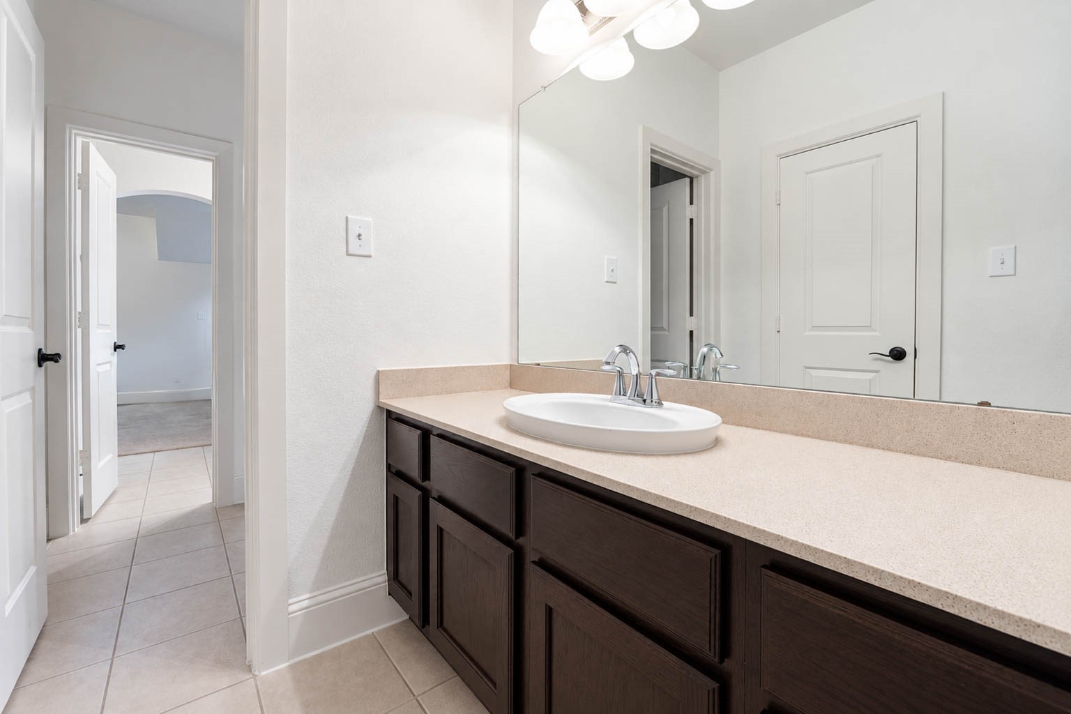 5403 Mesquite Ridge Street Fulshear, TX 77441 - Photo 34 of 42 The second vanity in the Hollywood bathroom gives the neighboring bedroom its own dedicated space, complete with a wide countertop, a large mirror, and polished nickel fixtures.