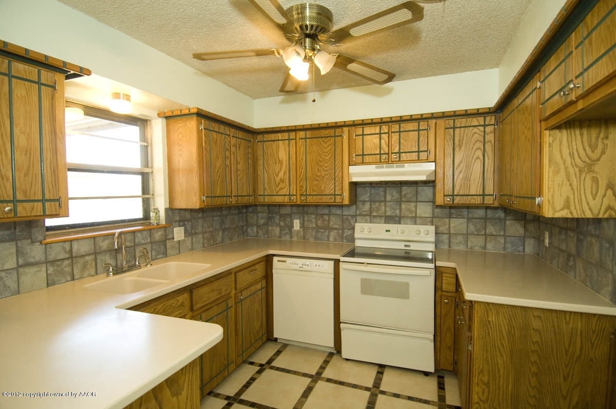 8206 Santa Fe Trail Amarillo, TX 79110 - Photo 11 of 31 a kitchen with stainless steel appliances granite countertop a sink a stove and cabinets