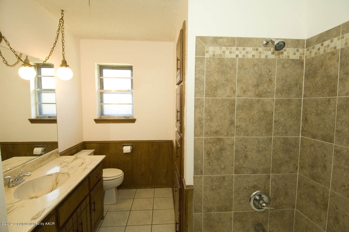 8206 Santa Fe Trail Amarillo, TX 79110 - Photo 23 of 31 a bathroom with a granite countertop sink a toilet and shower