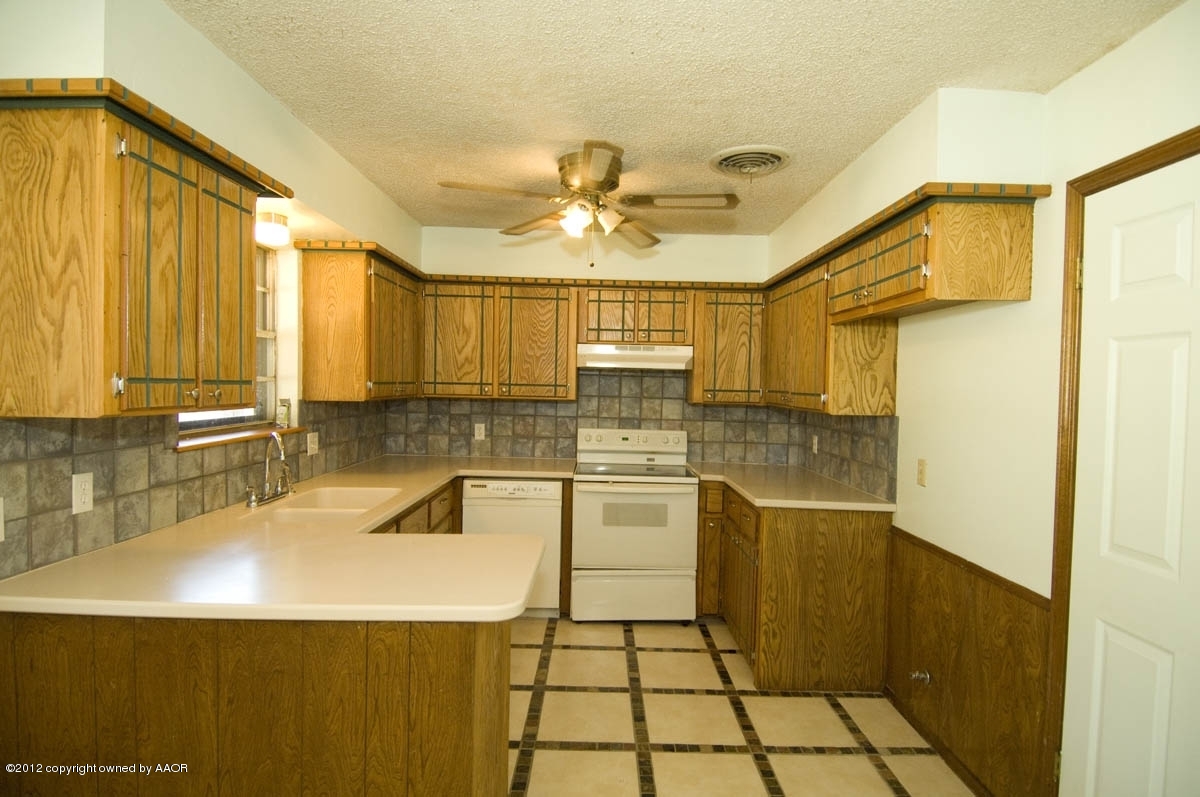 8206 Santa Fe Trail Amarillo, TX 79110 - Photo 8 of 31 a kitchen with a sink a stove and cabinets