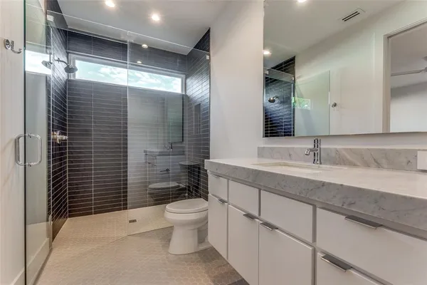 a bathroom with a sink a toilet and shower