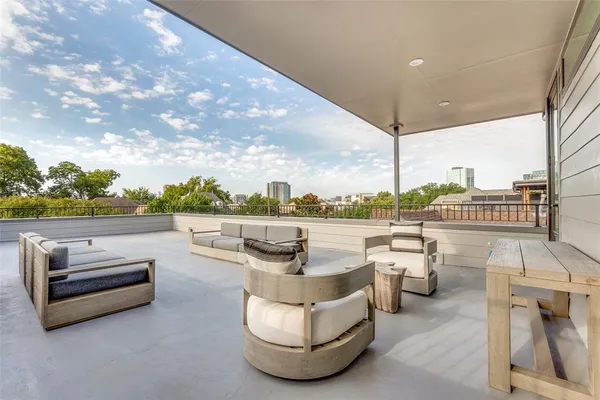 a view of roof deck with couches and city view