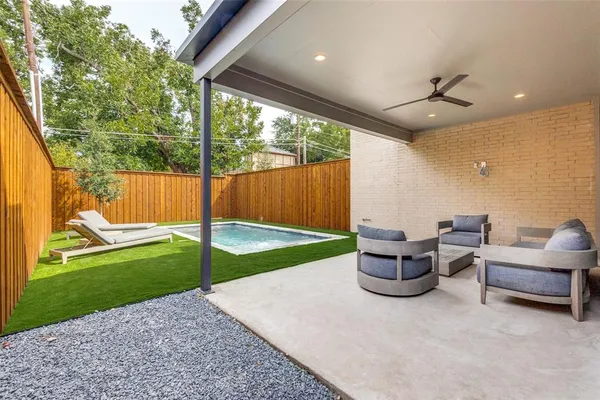 a living room with patio furniture and a garden