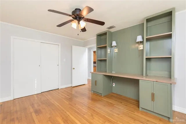a view of an empty room with a chandelier fan
